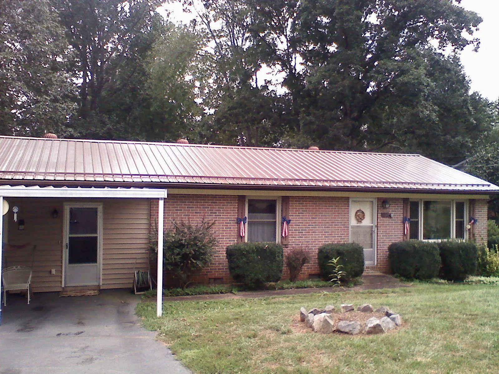 Bronze metal roof and carport on a brick ranch home — Roof Repair work by our crew in Exeter